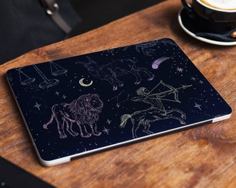 May include: A dark blue laptop skin with a white design of zodiac signs, including a lion, a centaur, and a scale. The background is a dark blue with white stars.