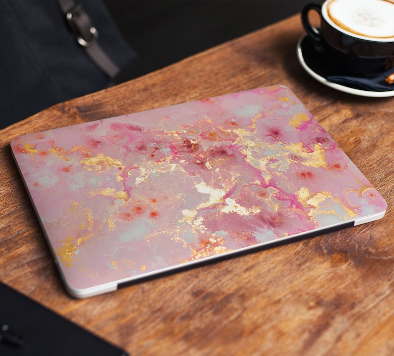 Pode incluir: Uma pele de laptop de m&aacute;rmore rosa e dourado com um padr&atilde;o de redemoinho.