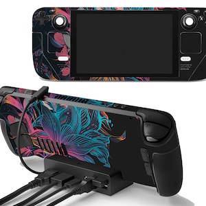 Pode incluir: Um console de jogos portátil preto com um design floral colorido. O console é mostrado com uma base e vários cabos.