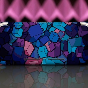 May include: A black and blue Nintendo Switch Lite console with a geometric pattern of squares and rectangles in shades of blue, purple, and pink.