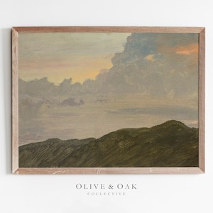 May include: A framed painting depicting a landscape with a cloudy sky and rolling hills in shades of green, brown, and purple. The sky is a soft pink and orange at the horizon.