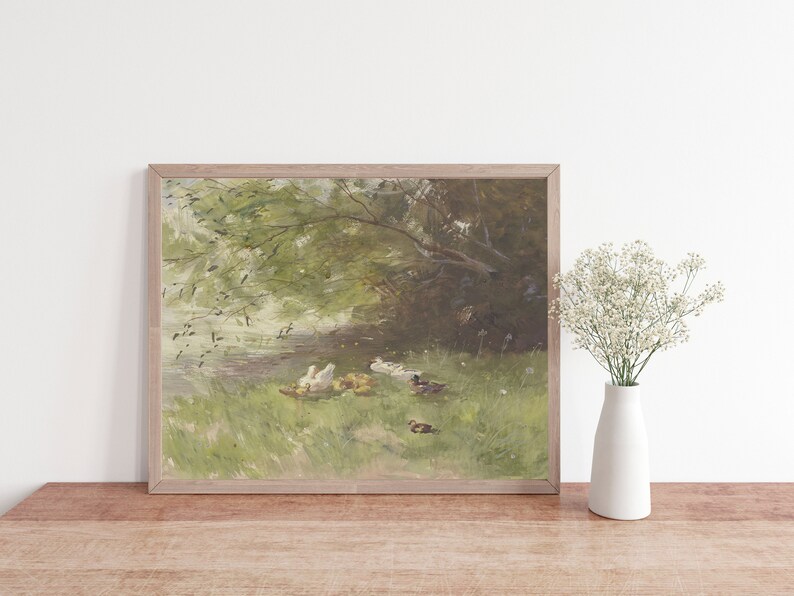 Puede incluir: Una pintura enmarcada que representa una escena pac&iacute;fica de patos y patitos reunidos junto a un estanque bajo un &aacute;rbol frondoso. La pintura est&aacute; realizada en una paleta suave y tenue de verdes, marrones y blancos.