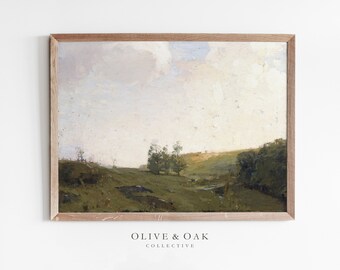 May include: A framed painting of a landscape with a cloudy sky, green hills, and a few trees. The painting is in a light brown frame.