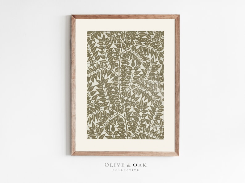 K&ouml;nnte beinhalten: Ein gerahmter Druck mit einer botanischen Illustration eines Blattmotivs in Gr&uuml;nt&ouml;nen auf wei&szlig;em Hintergrund. Der Rahmen ist aus hellem braunem Holz.