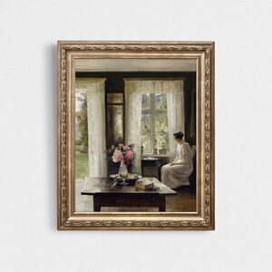 May include: A painting of a woman sitting by a window in a room with a table and flowers. The woman is wearing a white dress and looking out the window. The room is decorated with white curtains and a vase of pink flowers.