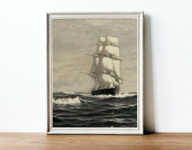 May include: A framed painting of a ship with white sails sailing on a choppy sea. The sky is a light gray with a hint of blue. The ship is in the foreground and the sea is in the background.