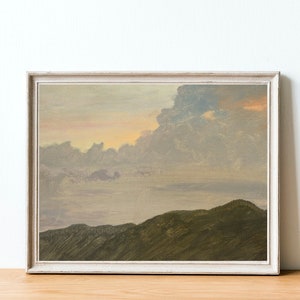 May include: A framed painting depicting a landscape with a cloudy sky and a mountain range in the foreground. The sky is a soft pink and purple, and the clouds are a light grey. The mountains are a dark green.