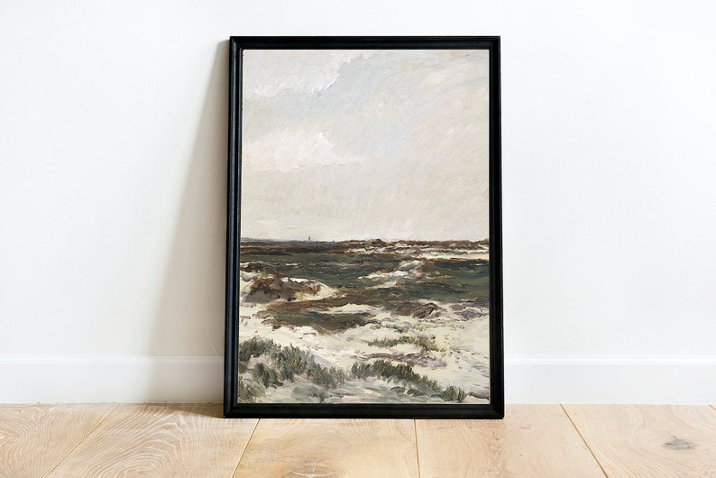 K&ouml;nnte beinhalten: Ein gerahmtes Gem&auml;lde, das eine Landschaft mit einem bew&ouml;lkten Himmel, gr&uuml;nem Gras und wei&szlig;en Sandd&uuml;nen zeigt. Das Gem&auml;lde ist in einem schwarzen Rahmen.
