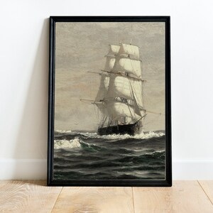 May include: A framed painting of a ship with white sails sailing on a dark blue sea. The ship is in the center of the image and is surrounded by waves. The sky is a light gray color.