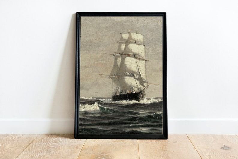 May include: A framed painting of a ship with white sails sailing on a dark blue sea. The ship is in the center of the image and is surrounded by waves. The sky is a light gray color.