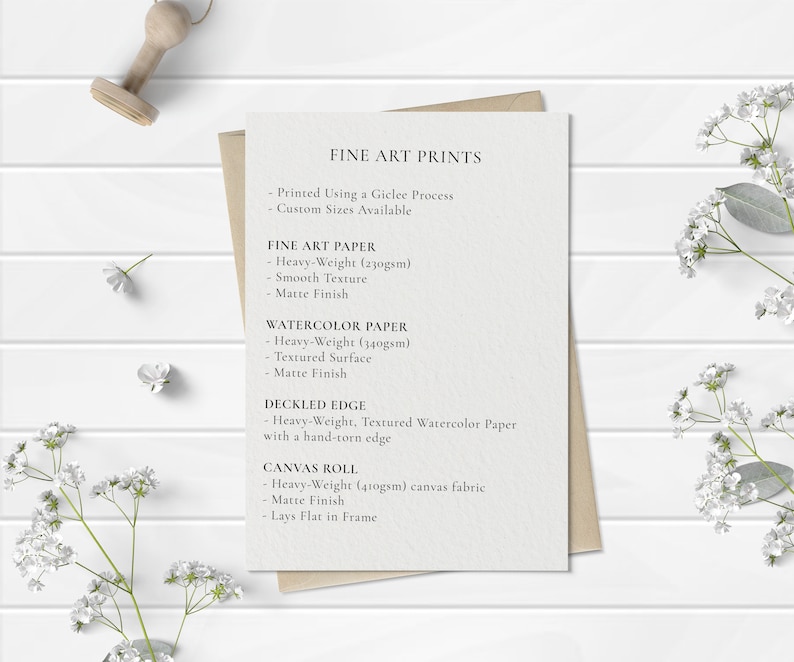 May include: A white card with the text "FINE ART PRINTS" printed on it. The card lists different paper types and their features, including "FINE ART PAPER", "WATERCOLOR PAPER", "DECKLED EDGE", and "CANVAS ROLL".