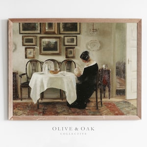 May include: A framed vintage painting shows a woman in a black dress seated at a table set for a meal. The room features antique furniture, framed artwork, and a chandelier. The painting is from the Olive & Oak Collective.