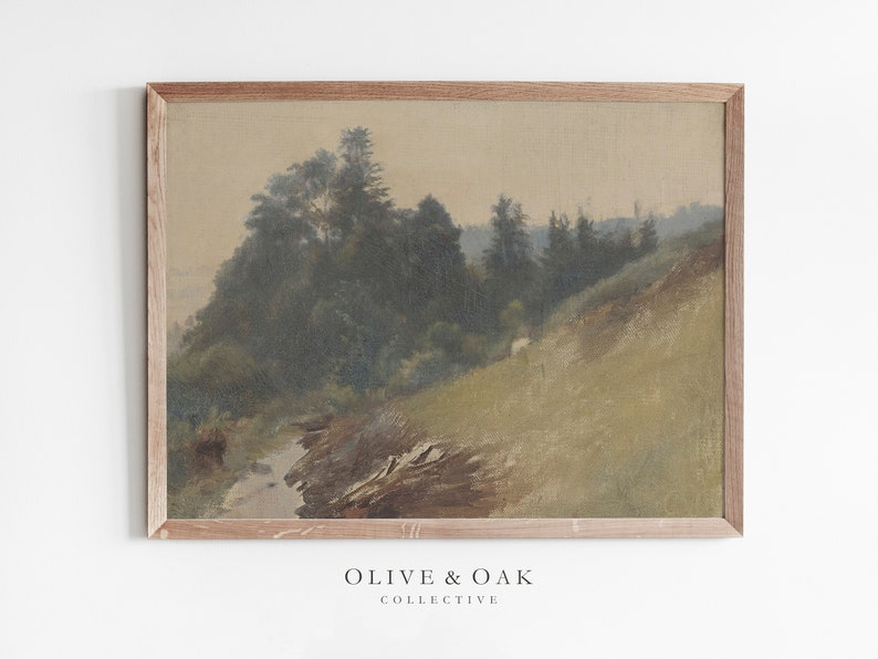 May include: A framed painting of a forest scene with a stream running through it. The painting is done in muted tones of green, brown, and beige. The frame is a simple, light brown wood.
