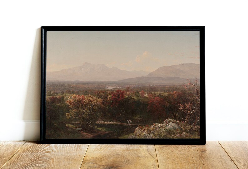 Puede incluir: Una pintura de paisaje enmarcada que representa un valle con monta&ntilde;as en la distancia. El valle est&aacute; cubierto de &aacute;rboles con follaje oto&ntilde;al en tonos de rojo, naranja y amarillo. El cielo es de un azul suave con un toque de rosa.