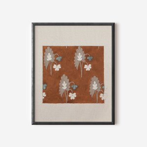 May include: A framed print of a floral pattern on a brown background. The flowers are white with blue centers and are arranged in a repeating pattern.