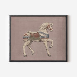 May include: A framed print featuring a vintage carousel horse. The horse is painted white with blue, red, and green accents on the saddle and harness. The background is a muted mauve color, and the frame is black.
