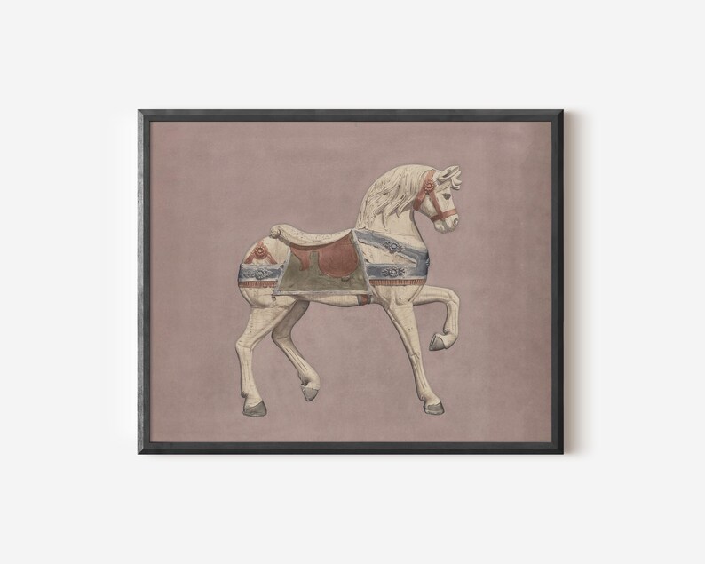 May include: A framed print featuring a vintage carousel horse. The horse is painted white with blue, red, and green accents on the saddle and harness. The background is a muted mauve color, and the frame is black.