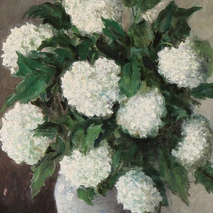 May include: A white ceramic vase with a blue and white pattern holds a bouquet of white hydrangeas with green leaves.