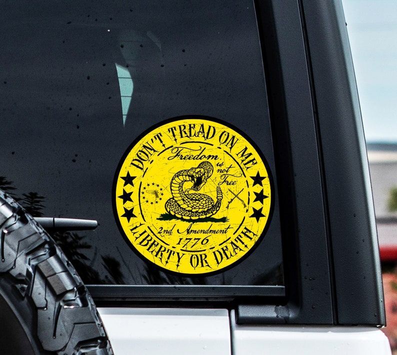 Op de afbeelding: Gele en zwarte "Don't Tread on Me" sticker met een ratelslang, gekruiste pistolen en de tekst "Freedom is not Free, 2nd Amendment 1776, Liberty or Death".