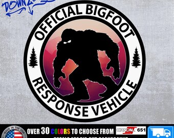 May include: A black and white circular sticker with the text "OFFICIAL BIGFOOT RESPONSE VEHICLE" around the edge. Inside the circle is a silhouette of Bigfoot walking through a red, orange, and purple mountain landscape. The sticker is made with Oracal 651 vinyl.
