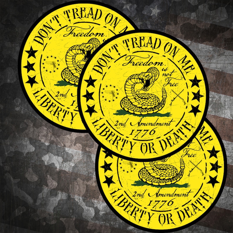 Op de afbeelding: Drie ronde gele stickers met een zwarte rand en een ratelslangontwerp. De stickers zeggen "Don't Tread On Me" en "Liberty or Death". De stickers hebben ook de tekst "2nd Amendment 1776" en "Freedom is not Free".