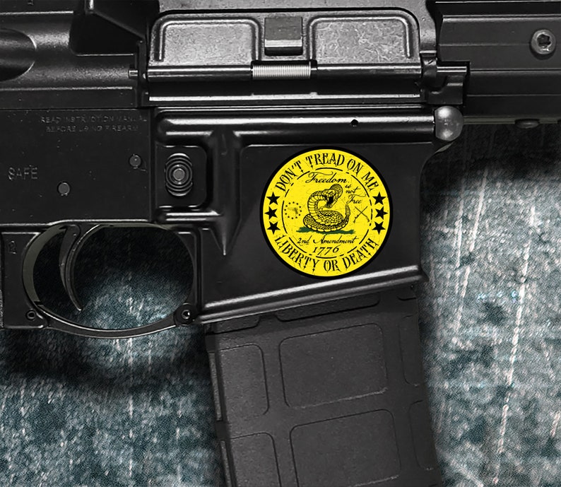 Op de afbeelding: Een zwart geweer met een gele sticker waarop "Don't Tread On Me" staat met een slang en de woorden "Freedom is not Free 2nd Amendment 1776 Liberty or Death".