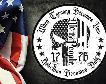 May include: A white circle with a black skull in the center. The skull is made up of an American flag on the left side and a black and white striped flag on the right side. The text around the skull reads "When Tyranny Becomes You Duty Rebellion Becomes We The People 1776".