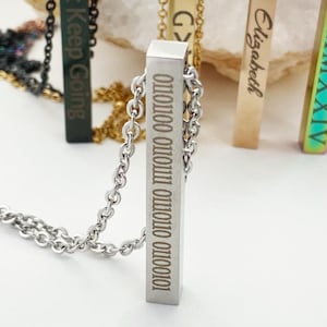 Pode incluir: Cinco colares de barra de prata com diferentes gravuras. As gravuras incluem "Just Keep Going", "Elizabeth", numerais romanos, "GX" e uma série de 0 e 1.