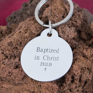 May include: Silver keychain with a round tag that says "Baptized in Christ 29.11.19 +"