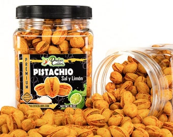 May include: A clear glass jar filled with pistachio nuts, labeled "Dulces Colibri Premium Pistachio Sal y Limón" with a net weight of 16 oz. The jar is spilling out onto a white background, showing the bright orange-colored pistachios.