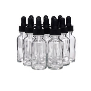 May include: A group of 12 clear glass bottles with black dropper caps. The bottles are arranged in a circle.
