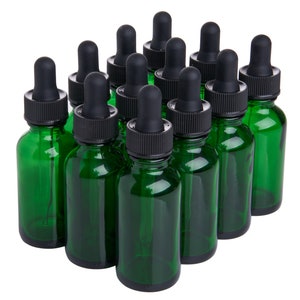May include: Ten green glass bottles with black dropper caps. The bottles are all the same size and shape, and they are arranged in a staggered pattern.