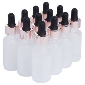 May include: Set of 10 frosted glass bottles with rose gold lids and black dropper tops.