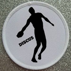 May include: White round fabric patch with a black silhouette of a person throwing a discus. The word "DISCUS" is printed in black below the silhouette.