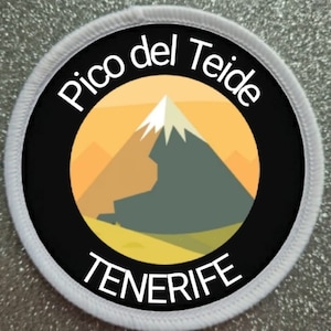 Peut inclure: Un patch rond blanc avec des détails noirs et jaunes. Le patch représente une montagne stylisée avec le texte "Pico del Teide TENERIFE" en blanc.