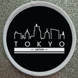 May include: White and black round patch with a white outline of the Tokyo skyline and the text "TOKYO - JAPAN -"