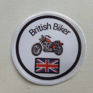 Op de afbeelding: Ronde witte patch met een zwarte rand. De patch toont een motorfiets, de tekst "British Biker" en een Union Jack-vlag.