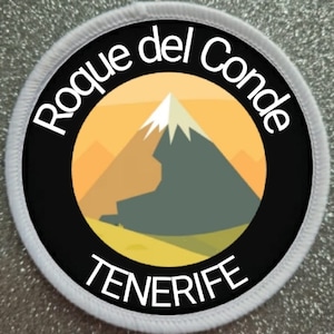 Puede incluir: Un parche circular blanco y negro con el texto "Roque del Conde TENERIFE" y una imagen estilizada de una montaña con un pico nevado.