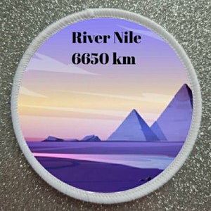 Può includere: Una toppa rotonda bianca con una scena di tramonto viola e giallo. Il testo "River Nile 6650 km" è stampato sulla toppa.