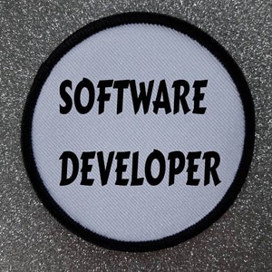May include: White round patch with black stitching around the edge. The text "SOFTWARE DEVELOPER" is printed in black.