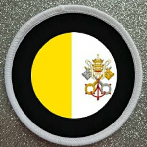 May include: A white circular patch with a black border and a yellow and white flag of Vatican City in the center. The flag features two crossed keys and a papal tiara.