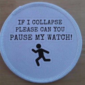 Puede incluir: Parche redondo blanco con texto negro que dice "IF I COLLAPSE PLEASE CAN YOU PAUSE MY WATCH!" y una silueta negra de una persona corriendo.