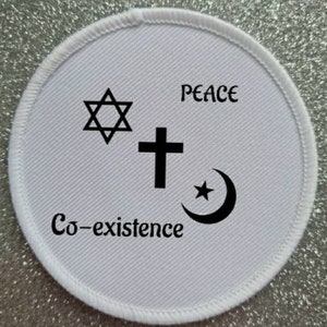 Könnte beinhalten: Weißer runder Patch mit einem Davidstern, einem Kreuz und einem Halbmond mit einem Stern. Der Text "Peace" befindet sich über den Symbolen und "Co-existence" darunter.