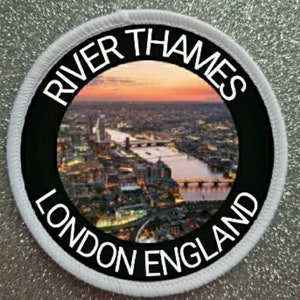 Peut inclure: Un écusson rond représentant une vue de Londres, en Angleterre, avec la Tamise. Le patch a une bordure noire avec le texte blanc "RIVER THAMES LONDON ENGLAND". L'image centrale montre un coucher de soleil sur la ville.