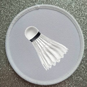 May include: White round fabric patch with a white badminton shuttlecock in the center.