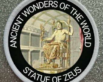 May include: A black and white circular patch with the text "Ancient Wonders of the World" and "Statue of Zeus" around a depiction of the Statue of Zeus, one of the Seven Wonders of the Ancient World.