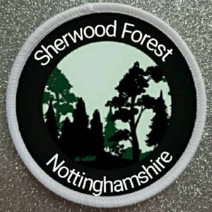 May include: White round patch with black text and a green silhouette of trees. The text reads "Sherwood Forest Nottinghamshire".