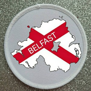 May include: White round patch with a red and white outline of Northern Ireland with the word "BELFAST" in red letters.