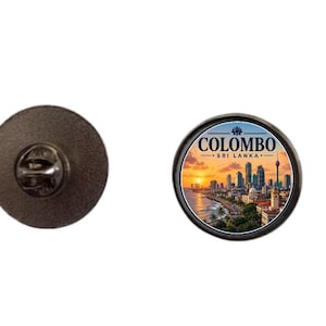 May include: A round metal pin featuring a vibrant sunset cityscape of Colombo, Sri Lanka, with the text Colombo Sri Lanka printed above the skyline. The back of the pin shows a dark textured metal surface with a standard butterfly clutch fastener.