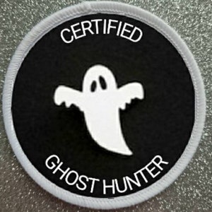 May include: White and black round patch with the text "CERTIFIED GHOST HUNTER" and a white ghost illustration.